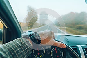 car travel concept man hand on steering wheel speedway