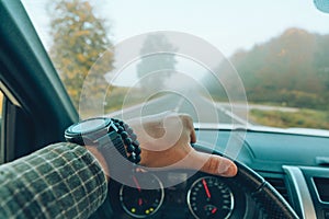 car travel concept man hand on steering wheel speedway