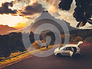 Car travel concept. People watch mountain sunset