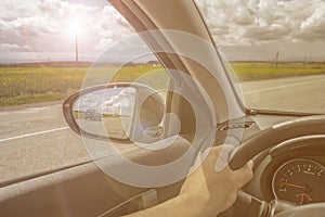 Car trip. Road view reflection on side mirror. Sunshine toned photo