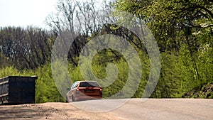 A car and a truck on a slope on a forest road. Back view.