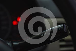 Car turn signal lever on dark background