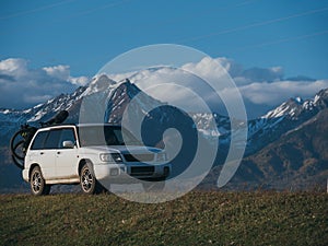 The car with two bicycle mounted to the roof bike with bikepacking. The trip outdoor road in mountain snow capped.