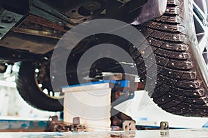 Car on two-post elevator in workshop service station.