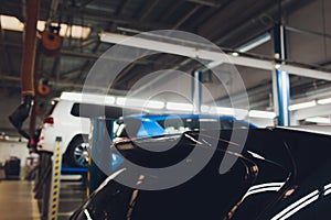 Car on two-post elevator in workshop service station.