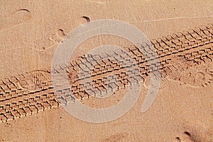 Car tyre traces on beach sand