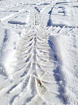 Car tyres marks on the snow , winter fun on the toad