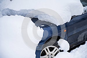 Car under a big snowdrift in winter.