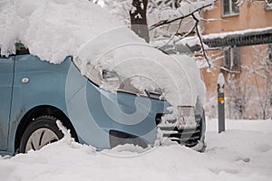 Car under a big snowdrift in winter.