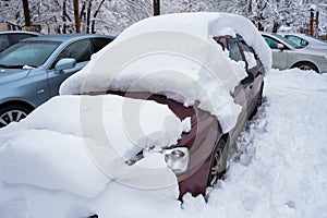 Car under a big snowdrift in winter.