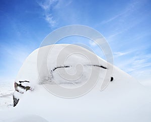 Car under deep snow in winter day