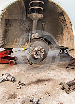 Car under repair on hoist at service station