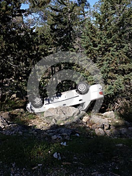 Car upside down between trees