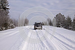 Car `VAZ-2105` on a snow-covered road in the countryside winter landscape