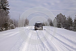 Car `VAZ-2105` on a snow-covered road in the countryside winter landscape photo