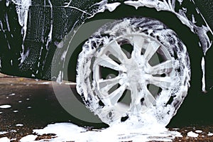 car wash with active foam soap. cleaning wheel tire.