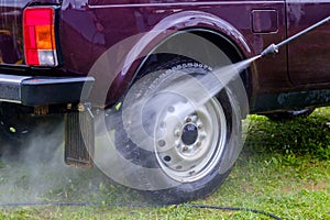 Car wash in the afternoon outdoors with a high-pressure apparatus.