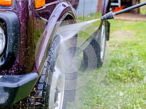 Car wash in the afternoon outdoors with a high-pressure apparatus.