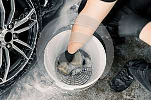 Car wash and detailing concept. Top view of washing tools in car wash service, white bucket with soap cleaning solution