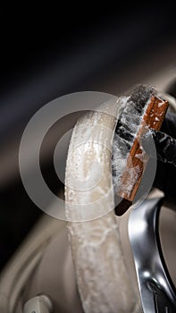 Car wash employee or a car detailing studio thoroughly cleans a light leather steering wheel