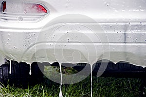 Car wash with flowing water and foam. Soap on the wheels. Close up macro