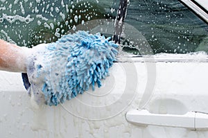 Car wash by hand. Soap suds and washing mitt.