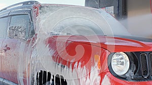 Car wash with high pressure water. The car is washed with soap at a car wash