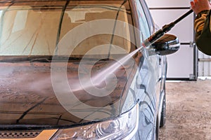 Car wash with Karcher. The man washes the black car photo