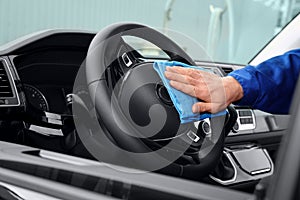 Car wash worker cleaning automobile interior, closeup