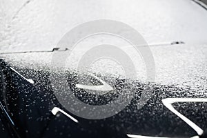 Car washing process. Foaming detergent covers side of the car, clean it from dirt and dust.