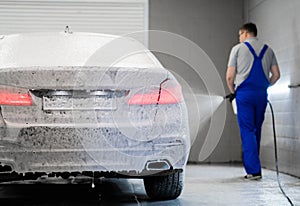 Car washing process. Foaming detergent covers side of the car, clean it from dirt and dust.