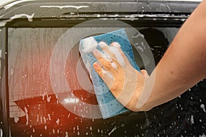 Car washing by using  sponge and cleaner at glass door