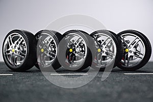 Car wheel, car tire standing on a road. Concept tyres. Car tire with a disc standing on the asphalt road. 3D