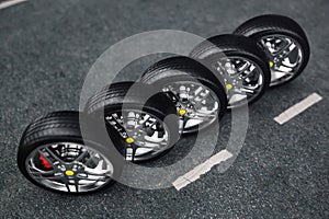 Car wheel, car tire standing on a road. Concept tyres. Car tire with a disc standing on the asphalt road. 3D