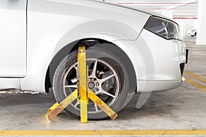 Car wheel clamped for illegal parking violation at car park