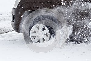 Car wheel close-up rides and skidding on a snowy winter road