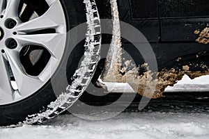 Car wheel with dirty stuck snow. Winter problems for drivers.