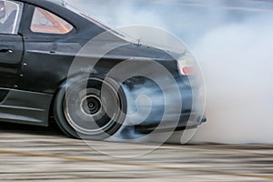 Car wheel drifting and smoking on track.