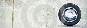 Car wheel on gray concrete background. Copy space. Transport. Spare parts.