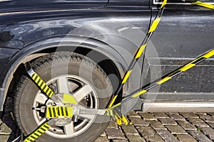 Car wheel is locked and booted due illegal parking violation. Police equipment for blocking the car wheel photo