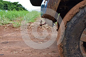 Car wheel off road with lots of dirt and terrain. car to rural areas. Modern blue car used for transport on farm. country