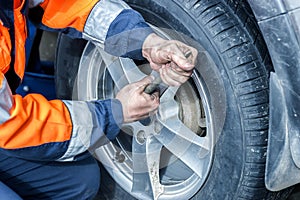 Car wheel replacement. Self-service tire fitting concept. Using a wheel wrench to twist the wheel nuts