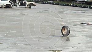 Car wheel rolling on asphalt after accident, crash. Junkyard