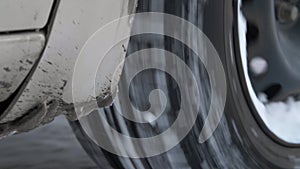 Car wheel is spinning while driving. Close up car moving in the snow. Car movement