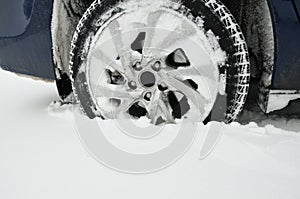 Car wheel stuck in the snow in the parking lot