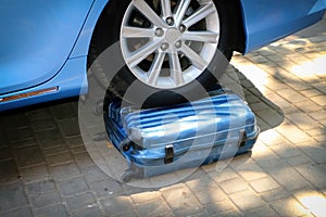 Car wheel on a suitcase, the car ran into a suitcase. photo