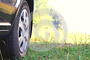 Car wheel with summer tires close-up on green grass