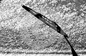 Car whiper blade and snow on glass with blur effect in black and white