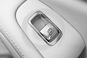 Car white leather interior details of door handle with windows controls and adjustments. Car window controls of modern car. Car de photo