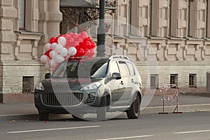 Car with white and red balloons